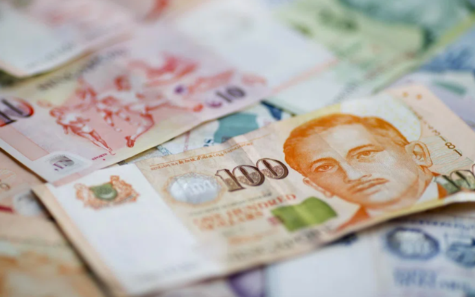 Close-up of Singapore dollar banknotes with S$100 note prominently displayed - visual representation of financial costs and losses faced by Singapore organisations