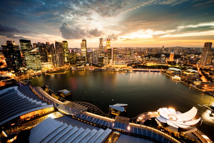 Singapore Marina Bay business district at dusk showing vibrant cityscape with illuminated skyscrapers